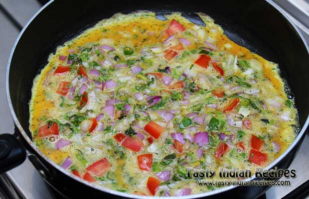 Spread egg mixture evenly and cook it on low flame for few minutes, till the eggs are set and omelette is well cooked from top Spread egg mixture evenly and cook it on low flame for few minutes, till the eggs are set and omelette is well cooked from top